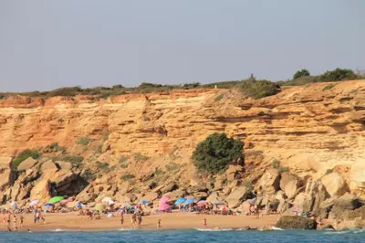 a group of people on a beach with umbrellas at Apartamento Cala de Puntalejo in Conil de la Frontera