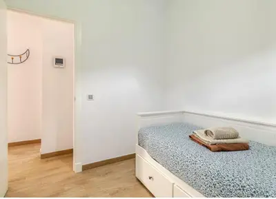 a white bedroom with a bed with a mirror at Fumiko in Sanlúcar de Barrameda