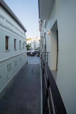an empty alley between two buildings with a balcony at Fumiko in Sanlúcar de Barrameda