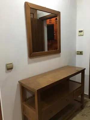 a wooden table with a mirror on a wall at Avenida Reyes Católicos in Chiclana de la Frontera