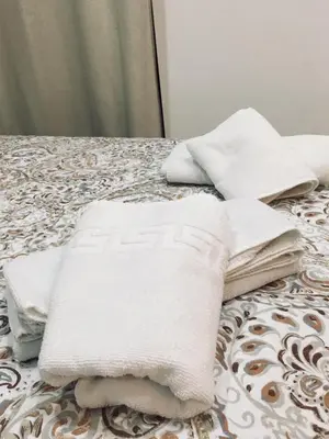 a pile of towels sitting on top of a bed at Avenida Reyes Católicos in Chiclana de la Frontera