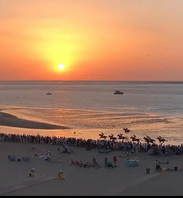 a crowd of people on a beach at sunset at Casa con Piscina en Sanlucar de Barrameda in Sanlúcar de Barrameda