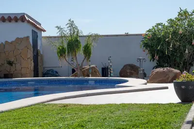 a swimming pool in a yard next to a house at Los años locos in Conil de la Frontera