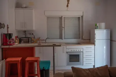 a kitchen with white cabinets and a white refrigerator at Los años locos in Conil de la Frontera