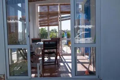a room with sliding glass doors with a table and chairs at Los años locos in Conil de la Frontera