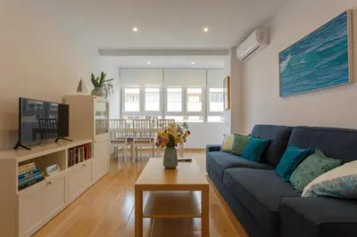 a living room with a blue couch and a table at Casa Ros-PLAYA free parking by Cadiz4Rentals in Cádiz