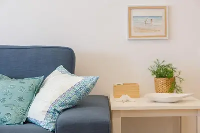 a blue chair sitting next to a table with pillows at Casa Ros-PLAYA free parking by Cadiz4Rentals in Cádiz