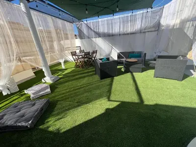 a tent with chairs and a table in the grass at Casa Ana in Sanlúcar de Barrameda