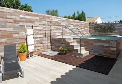 a swimming pool in a backyard with a brick wall at Villa Ébano in Conil de la Frontera