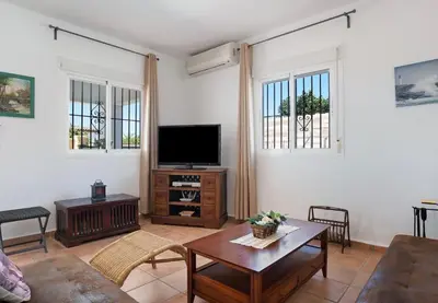 a living room with a tv and a table at Villa Ébano in Conil de la Frontera