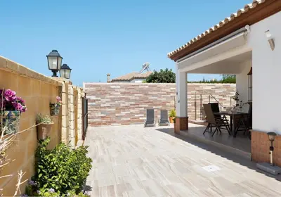 a patio of a house with a brick wall at Villa Ébano in Conil de la Frontera