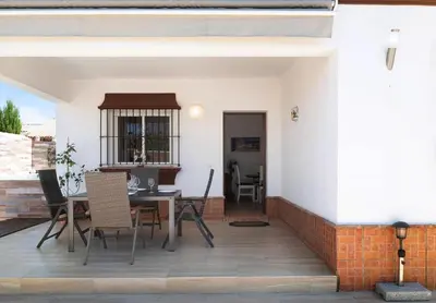 a patio with a table and chairs on it at Villa Ébano in Conil de la Frontera