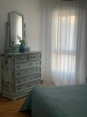 a bedroom with a dresser with a mirror and a window at Sanlúcar Playa in Sanlúcar de Barrameda