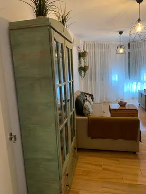 a living room with a couch and a large glass cabinet at Sanlúcar Playa in Sanlúcar de Barrameda