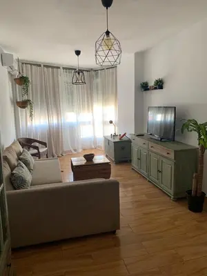 a living room with a couch and a flat screen tv at Sanlúcar Playa in Sanlúcar de Barrameda