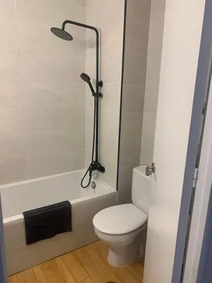 a bathroom with a toilet and a bath tub with a shower at Sanlúcar Playa in Sanlúcar de Barrameda