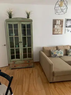 a living room with a couch and a glass cabinet at Sanlúcar Playa in Sanlúcar de Barrameda