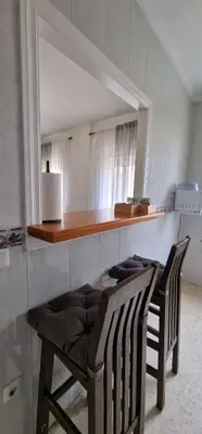 a kitchen with two chairs and a counter with a mirror at apartamento céntrico jerez calle tucan n17 in Jerez de la Frontera