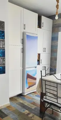 a kitchen with white cabinets and a refrigerator at La Barrosa duplex in Chiclana de la Frontera