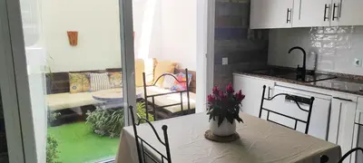 a kitchen with a table with a vase of flowers on it at La Barrosa duplex in Chiclana de la Frontera