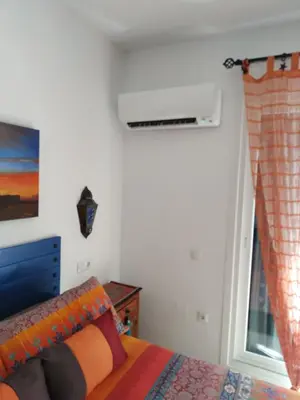a bedroom with a bed and a window at La Barrosa duplex in Chiclana de la Frontera