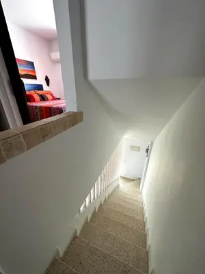 a staircase leading to a bedroom with a red bed at La Barrosa duplex in Chiclana de la Frontera