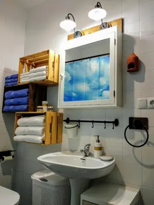 a bathroom with a sink and a mirror and towels at La Barrosa duplex in Chiclana de la Frontera