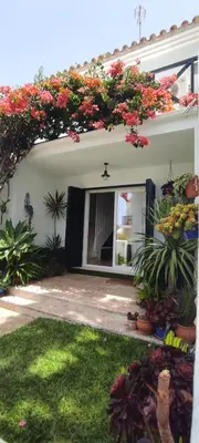 a house with flowers on the side of it at La Barrosa duplex in Chiclana de la Frontera