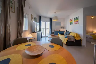 a living room with a table and a bedroom at Apartamento El Rayo Verde in Cádiz