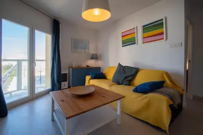 a living room with a yellow couch and a table at Apartamento El Rayo Verde in Cádiz
