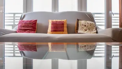 a white couch with pillows on top of a glass table at Apartamento Paseo Maritimo 27 in Cádiz