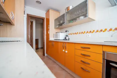 a kitchen with orange cabinets and a white counter top at Apartamento Paseo Maritimo 27 in Cádiz