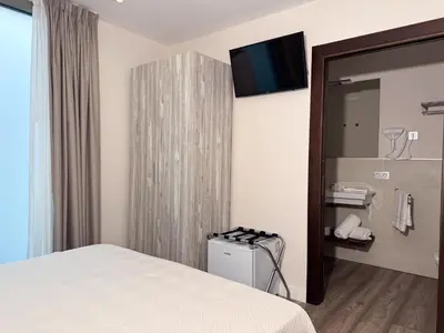 a hotel room with a bed and a mirror at Hotel Boutique Aroma de Mar in Chiclana de la Frontera