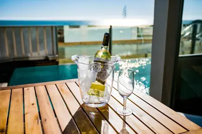 a bottle of wine and two glasses on a table at Hotel Boutique Aroma de Mar in Chiclana de la Frontera