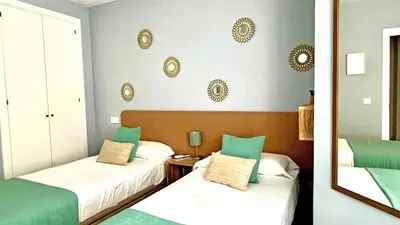 a bedroom with two beds with green and white at Sunset Victoria Beach in Cádiz