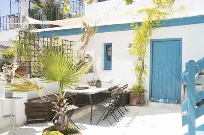 a patio with a table and chairs and a blue door at amazing Penthouse Cadiz in Cádiz