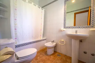 a bathroom with a toilet and a sink and a mirror at Chalet Miriam I in Conil de la Frontera
