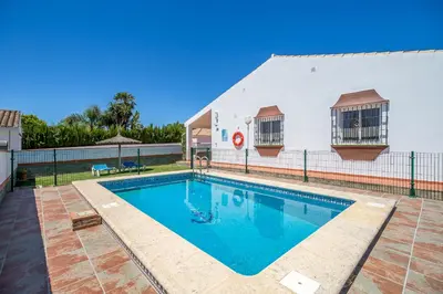 a swimming pool in front of a building at Chalet Miriam I in Conil de la Frontera