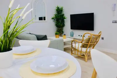 a living room with a table with white plates on it at Gosol Lemon, Centro-Parking in Sanlúcar de Barrameda