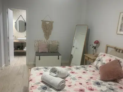 a bedroom with a bed and a mirror at Gosol Lemon, Centro-Parking in Sanlúcar de Barrameda