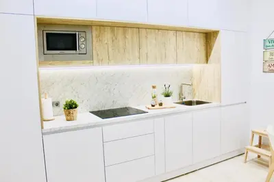 a kitchen with white cabinets and a microwave at Gosol Lemon, Centro-Parking in Sanlúcar de Barrameda