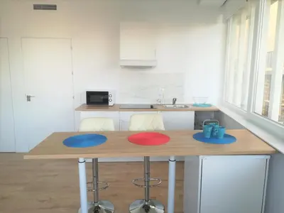 a kitchen with a table with blue and red mats on it at Luz de Cádiz in Cádiz