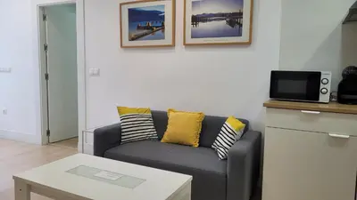 a living room with a couch and a tv at Luz de Cádiz in Cádiz
