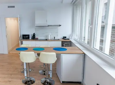 a kitchen with a table and stools in a room at Luz de Cádiz in Cádiz