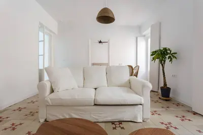 a white couch in a living room with a plant at SH La Casa del Loro. Amplio apartamento. in Cádiz
