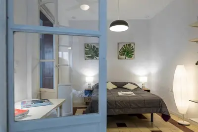 a bedroom with a bed and a table and a window at SH La Casa del Loro. Amplio apartamento. in Cádiz