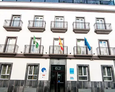a building with three flags in front of it at Plaza de la Luz Cádiz in Cádiz