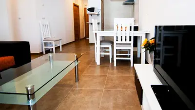 a living room with a glass table and chairs at Plaza de la Luz Cádiz in Cádiz