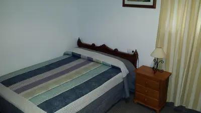 a bedroom with a bed and a night stand with a lamp at Hostal Cuesta de Belén in Arcos de la Frontera