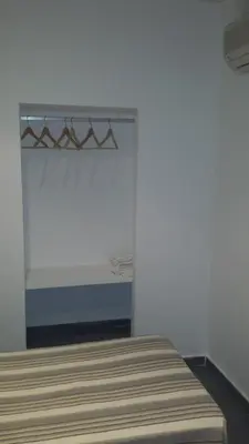 a bedroom with a bed and a white wall at Hostal Cuesta de Belén in Arcos de la Frontera